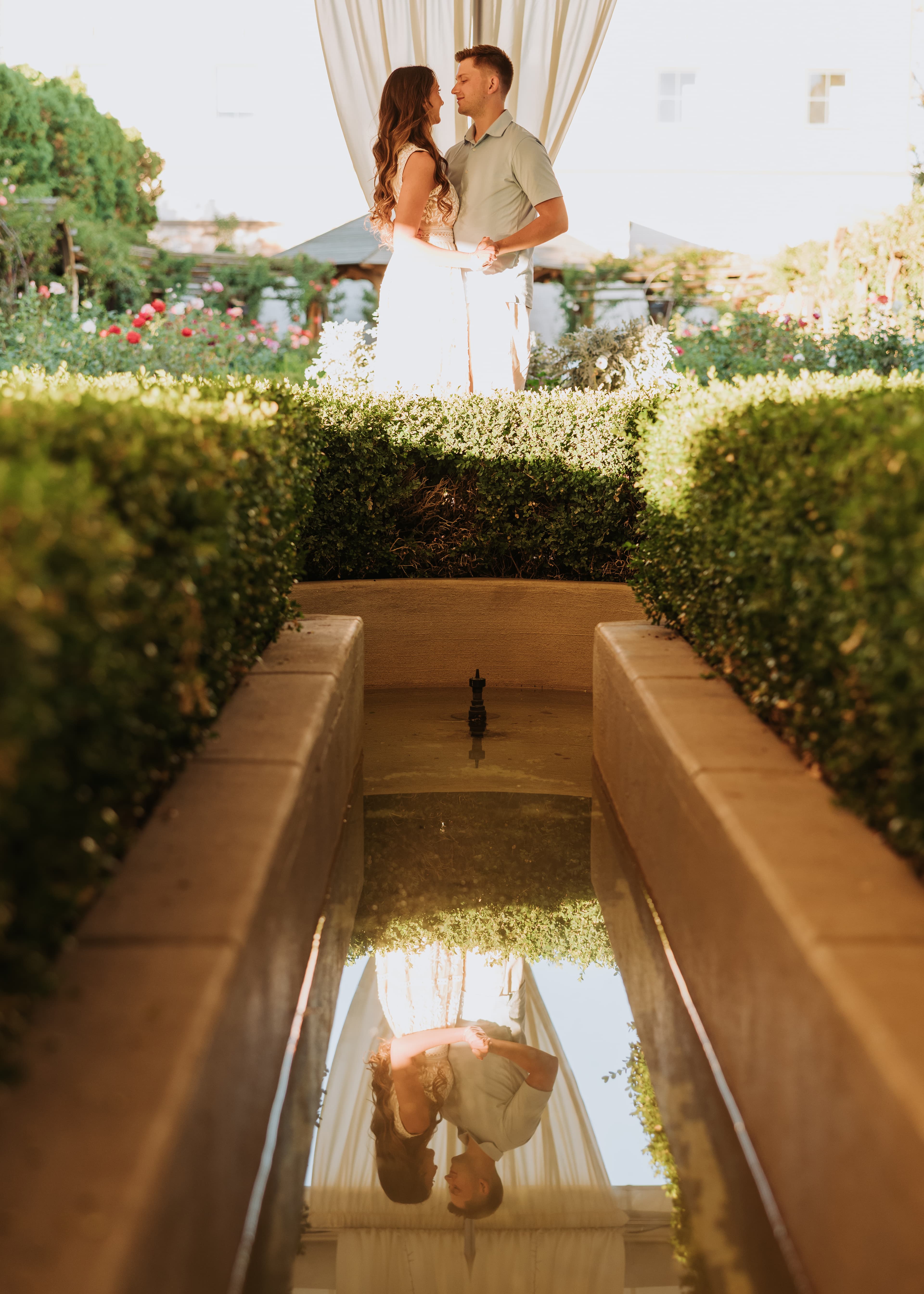 Bre and Bronson in a sunlit gazebo, reflected in the fountain below